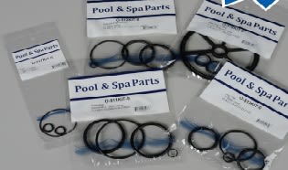 Packages containing the Aladdin Spider Gasket for Backwash Valve 2", various O-rings, and Magic Lube® are laid out on a surface.