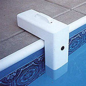 A Poolguard I/G Pool Alarm (PGRM-2) with a safety sensor is installed at the water's edge of an in-ground pool.