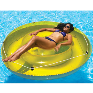 A woman in a bikini relaxes on the Swimline 72" SunTan Island Pool Lounger (9050) by Swimline, floating in a swimming pool.