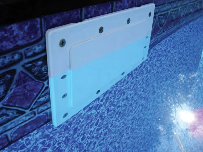 Close-up of the Pool Goods SimPoolTec Standard I/G Skimmer Plug for SP1084 (IGSD-H) attached to a tiled pool wall, with water partially covering it—ideal for securely winterizing and closing in-ground pool skimmers.
