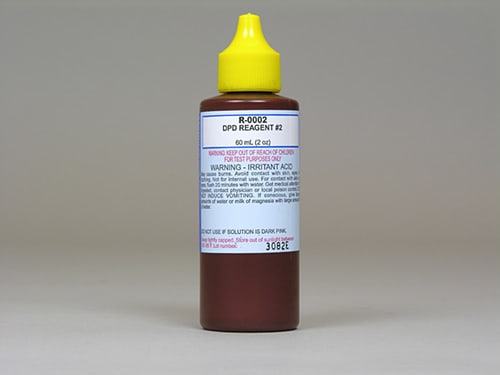 The Taylor DPD Reagent #2 Dropper Bottle, 2 oz, R-0002-C-12, is a brown bottle with a yellow cap for testing pool water's residual chlorine levels. The label includes warning instructions in bold red and black text.