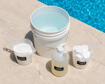 Cal hypo granules, a jug of liquid pool chlorine, and trichlor tabs arranged on a pool deck for comparison.