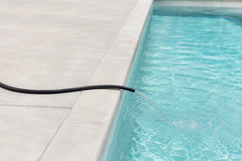 Hose filling a pool with freshwater