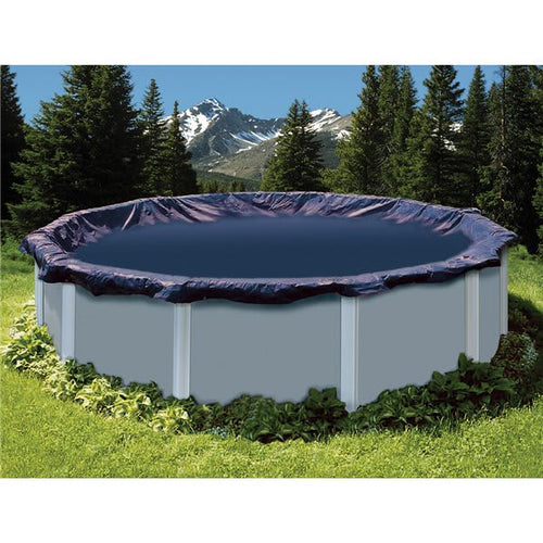 An above-ground pool with a dark cover is set in a grassy area, surrounded by trees and mountains in the background.