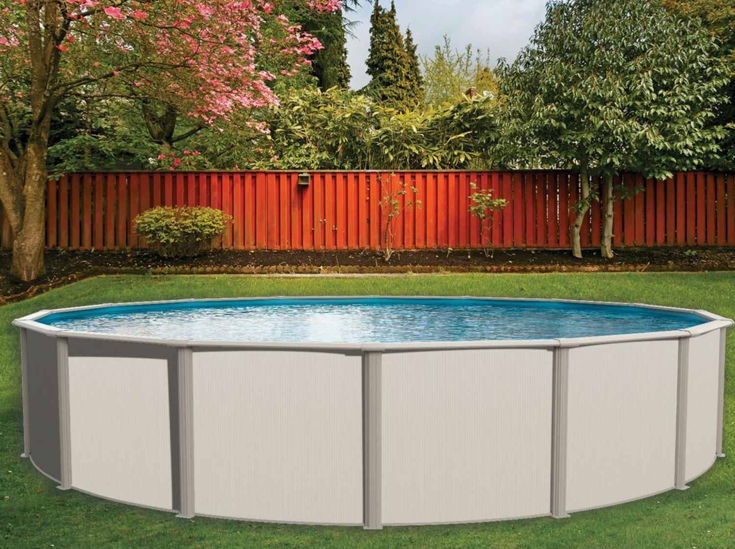 A Heritage Pool Supply Group Springfield 52 - Pool Package (HS2452SEA) is nestled in a lush backyard, enclosed by a red wooden fence and surrounded by trees and shrubs.